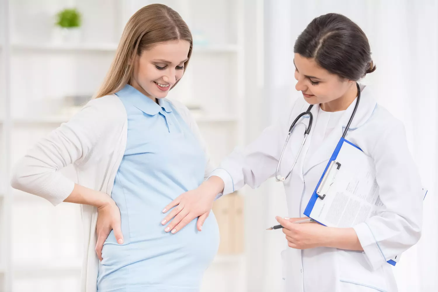 Une sage-femme examine une patiente enceinte lors d'une consultation prénatale